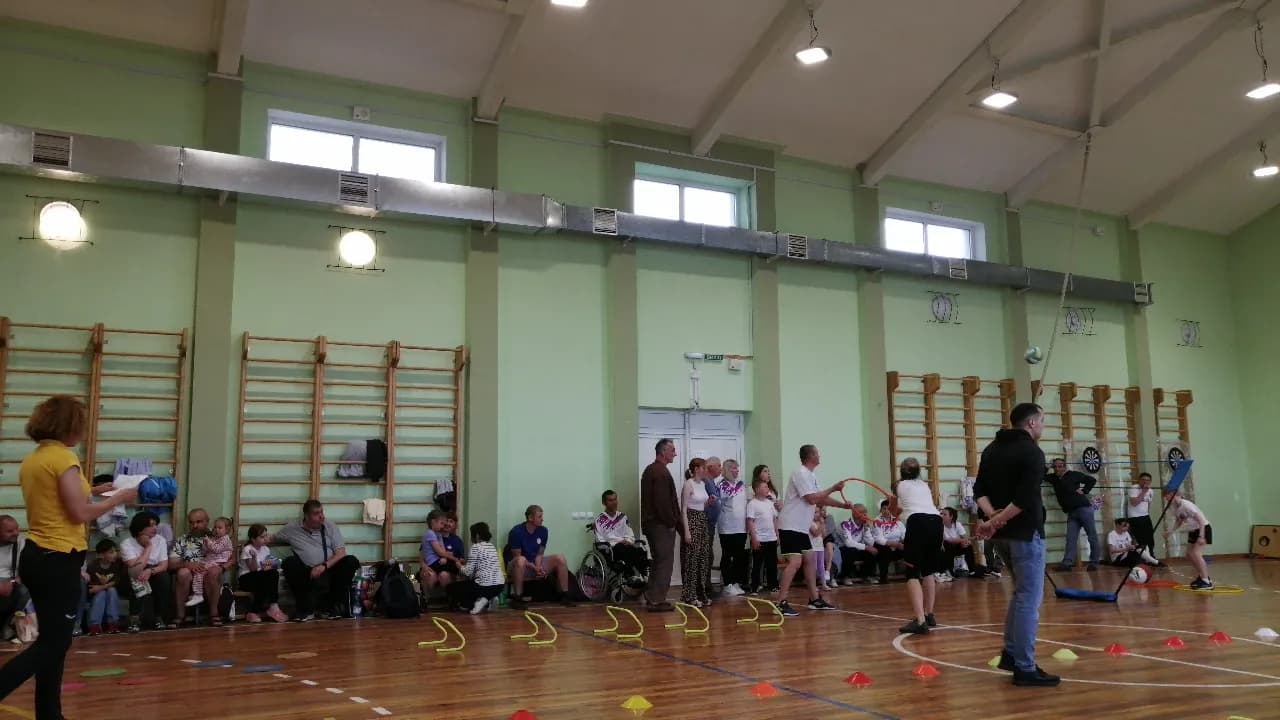 Учасники виконують командні вправи з обручами та спортивним інвентарем у спортзалі