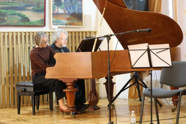 Подружжя піаністів з Литви грають на роялі в Палаці Потоцьких