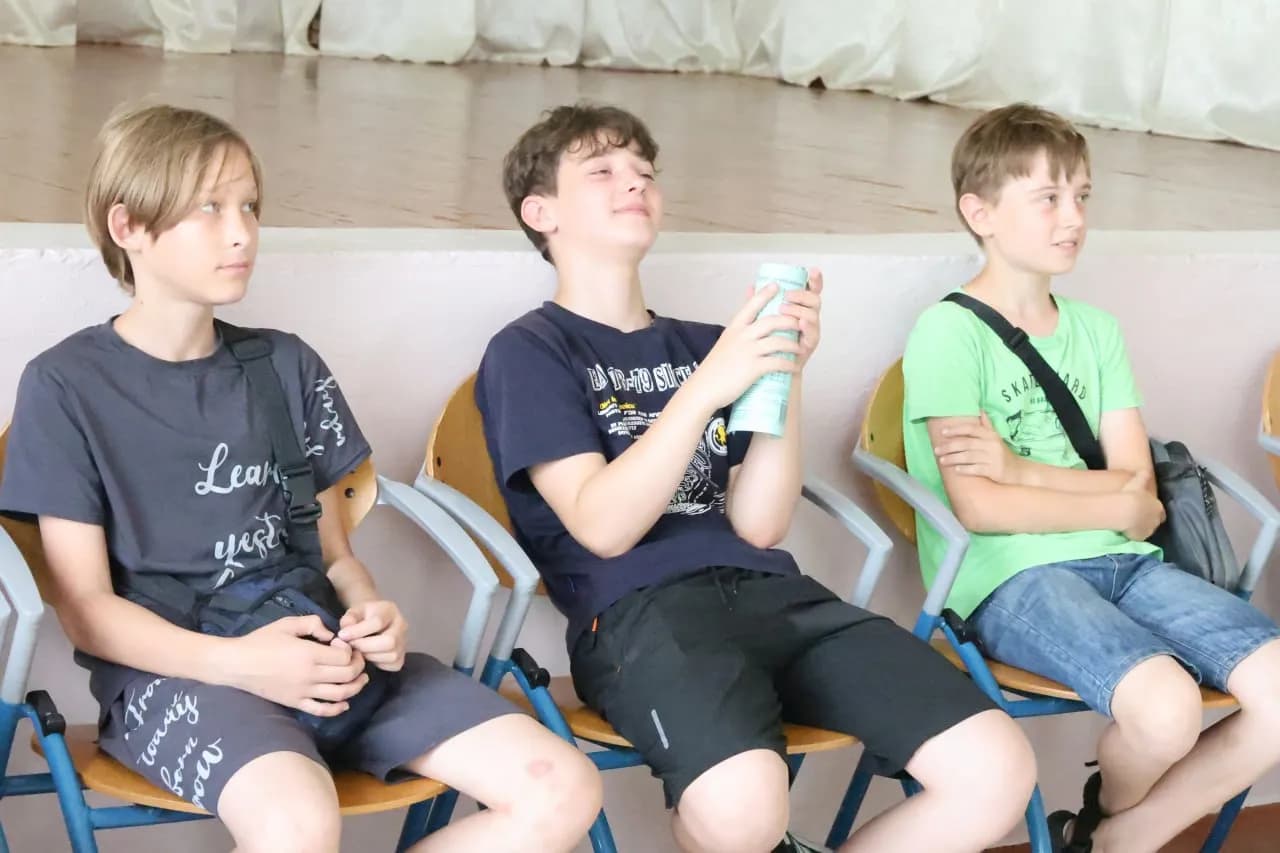 твоє хлопців сидять на стільцях