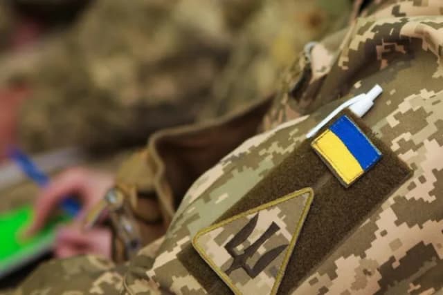 піксельна форма з жовто-блакитним патчем на рукаві