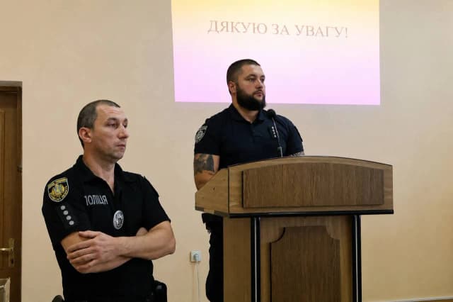Поліцейські біля трибуни слухають запитання депутатів