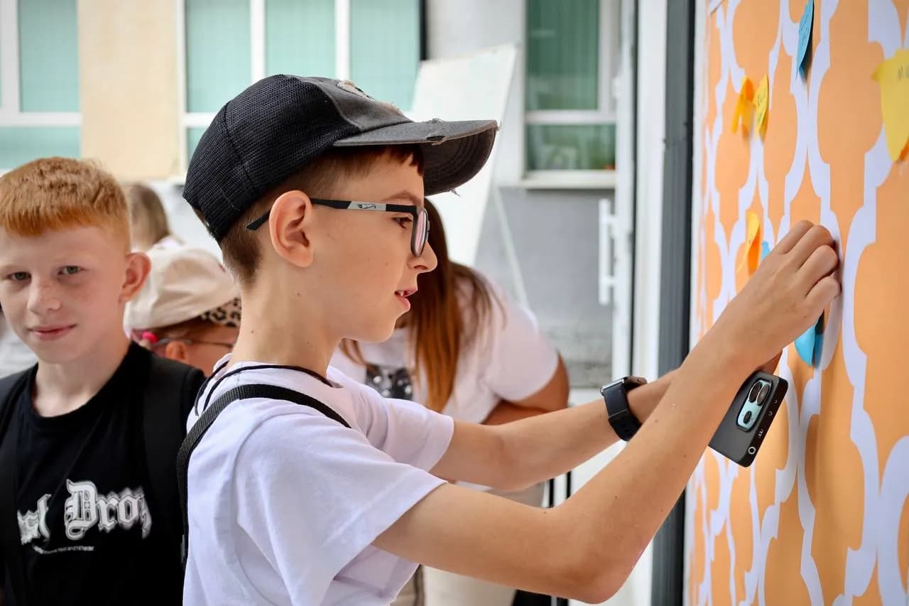 Хлопчик ліпить наклейку