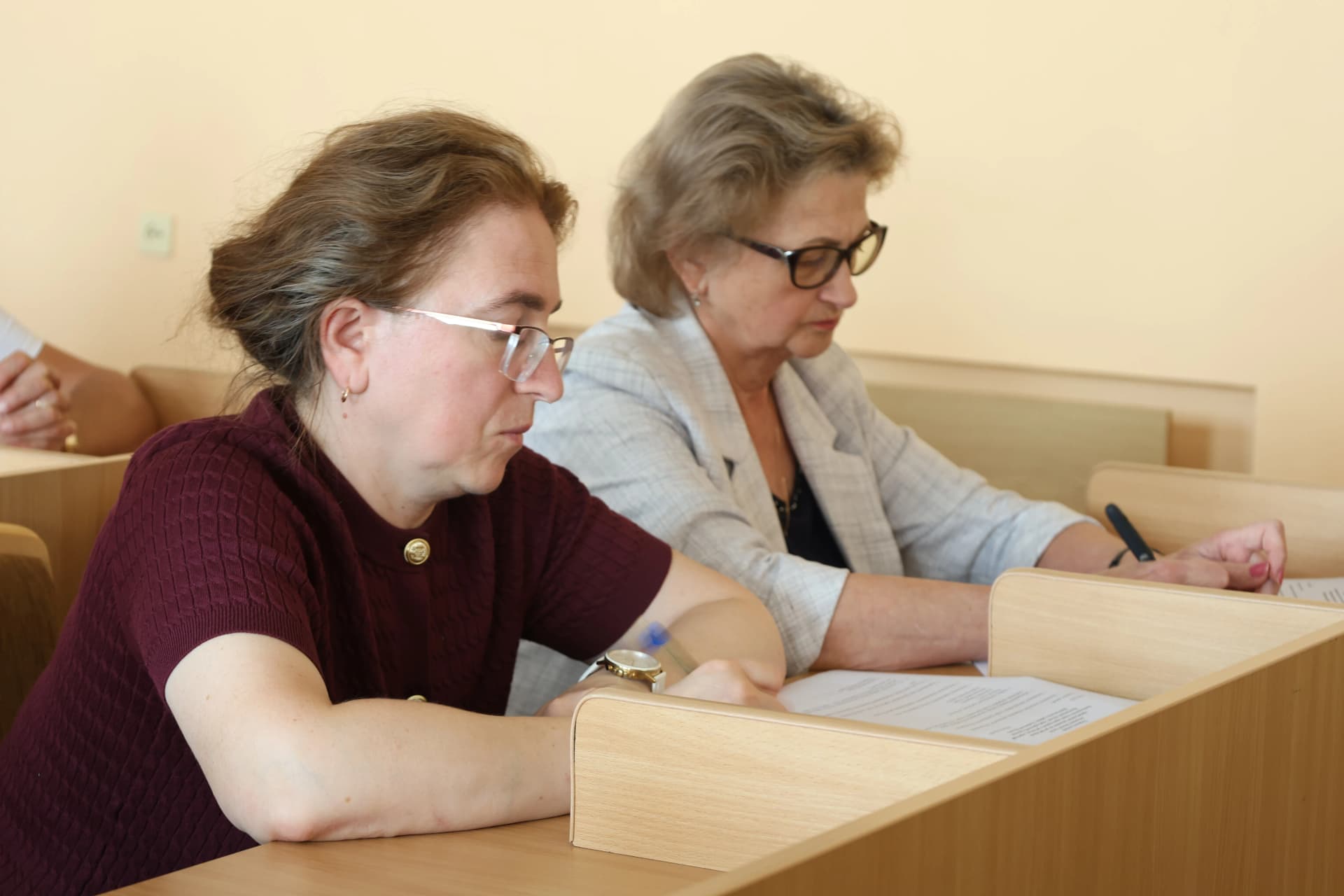 двоє жінок за столами в сесійній залі