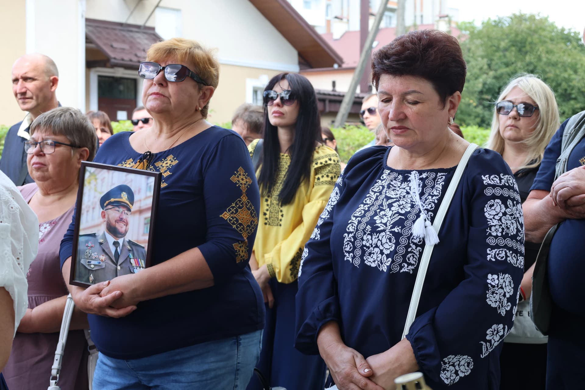 троє жінок з портретом військового