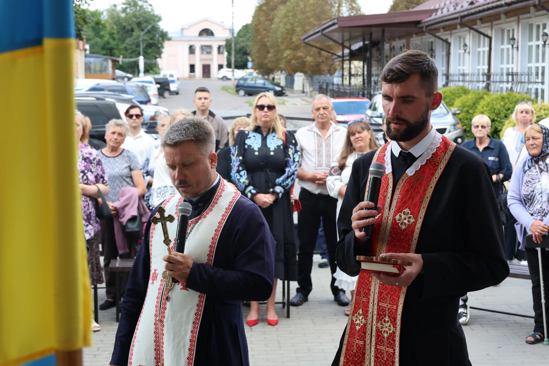 два священики перед меморіальною дошкою