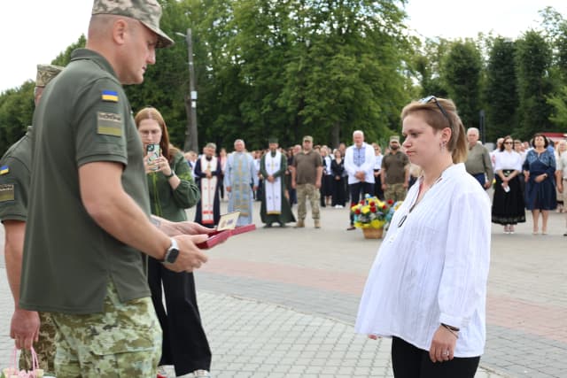 військовий вручає нагороду дружині Героя