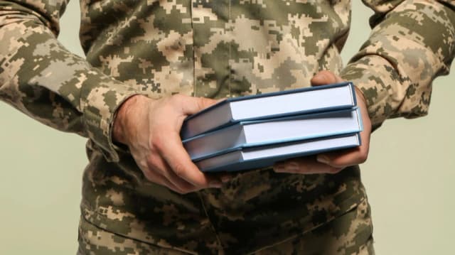 ветеран тримає книги в руках