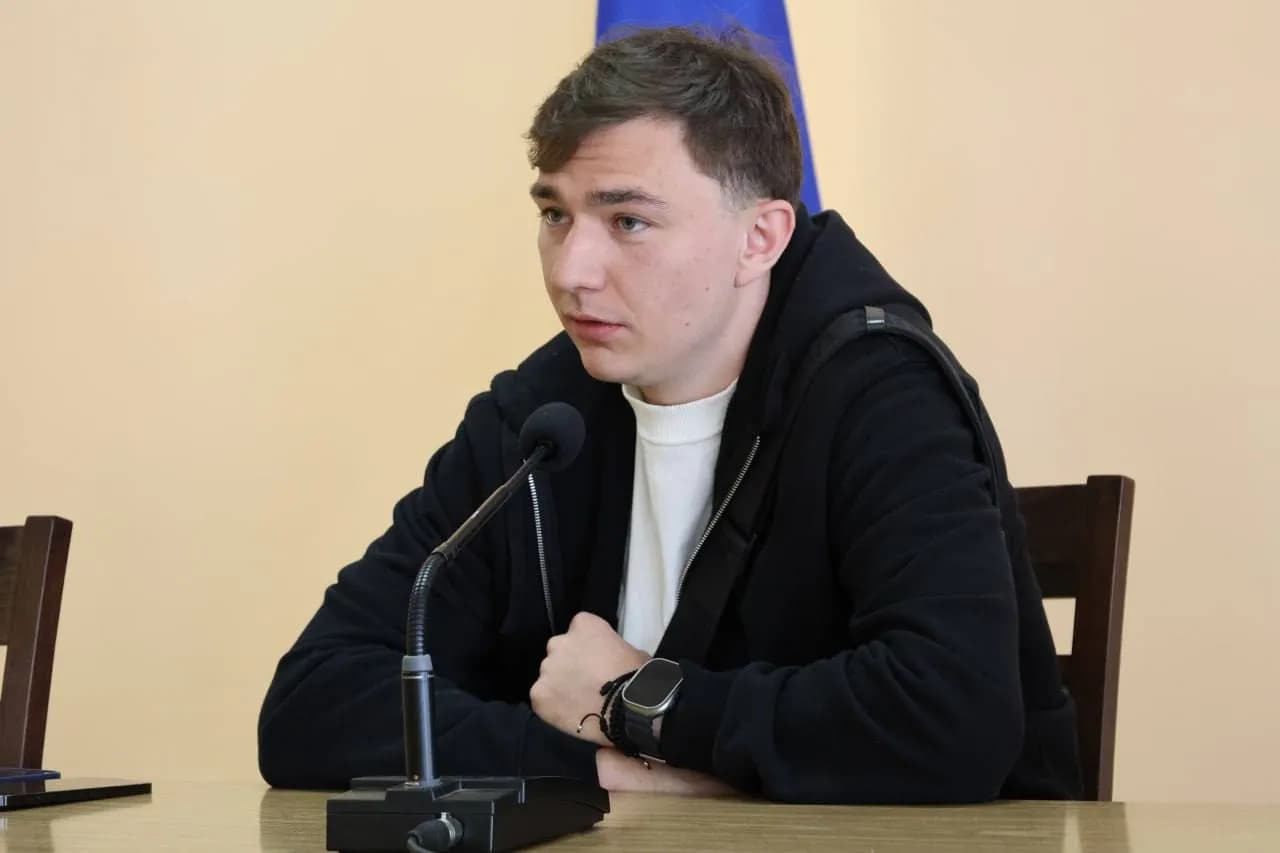 хокейст Віталій Лялька сидить біля мікрофону та розповідає свою історію