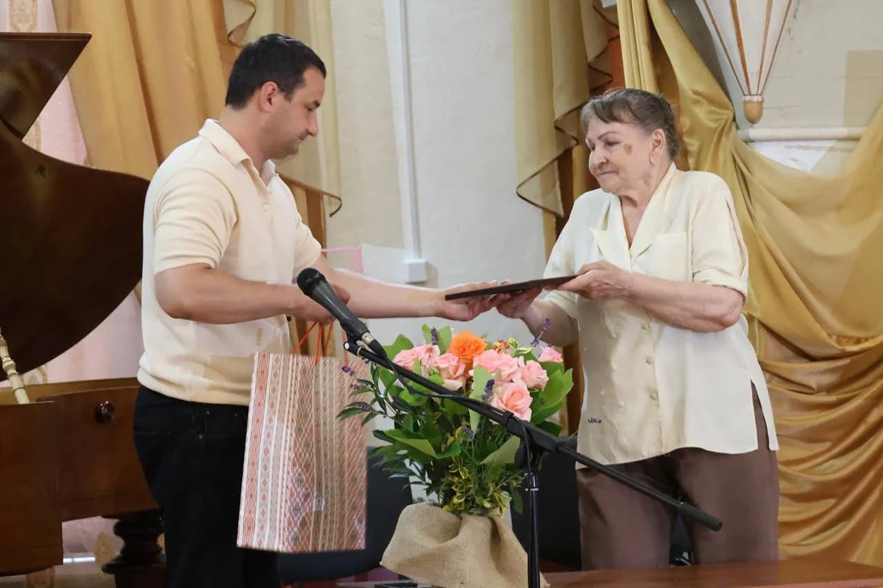 начальник відділу культури Андрій Процик вручає подарунки дружині Адама Бачі - Еллі Сенчуковій-Бача
