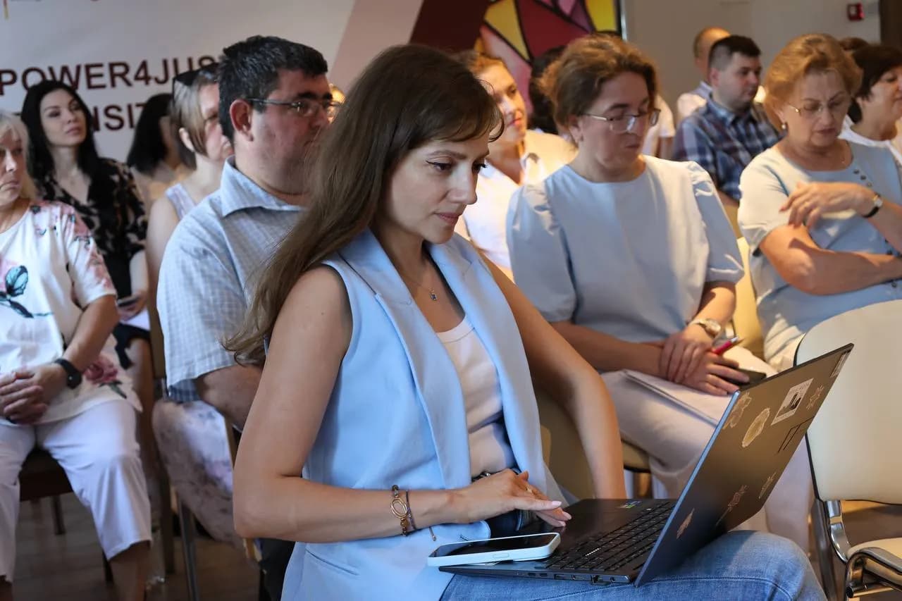 Представниця Асоціації вугільних громад України в комп'ютері налаштовує презентацію
