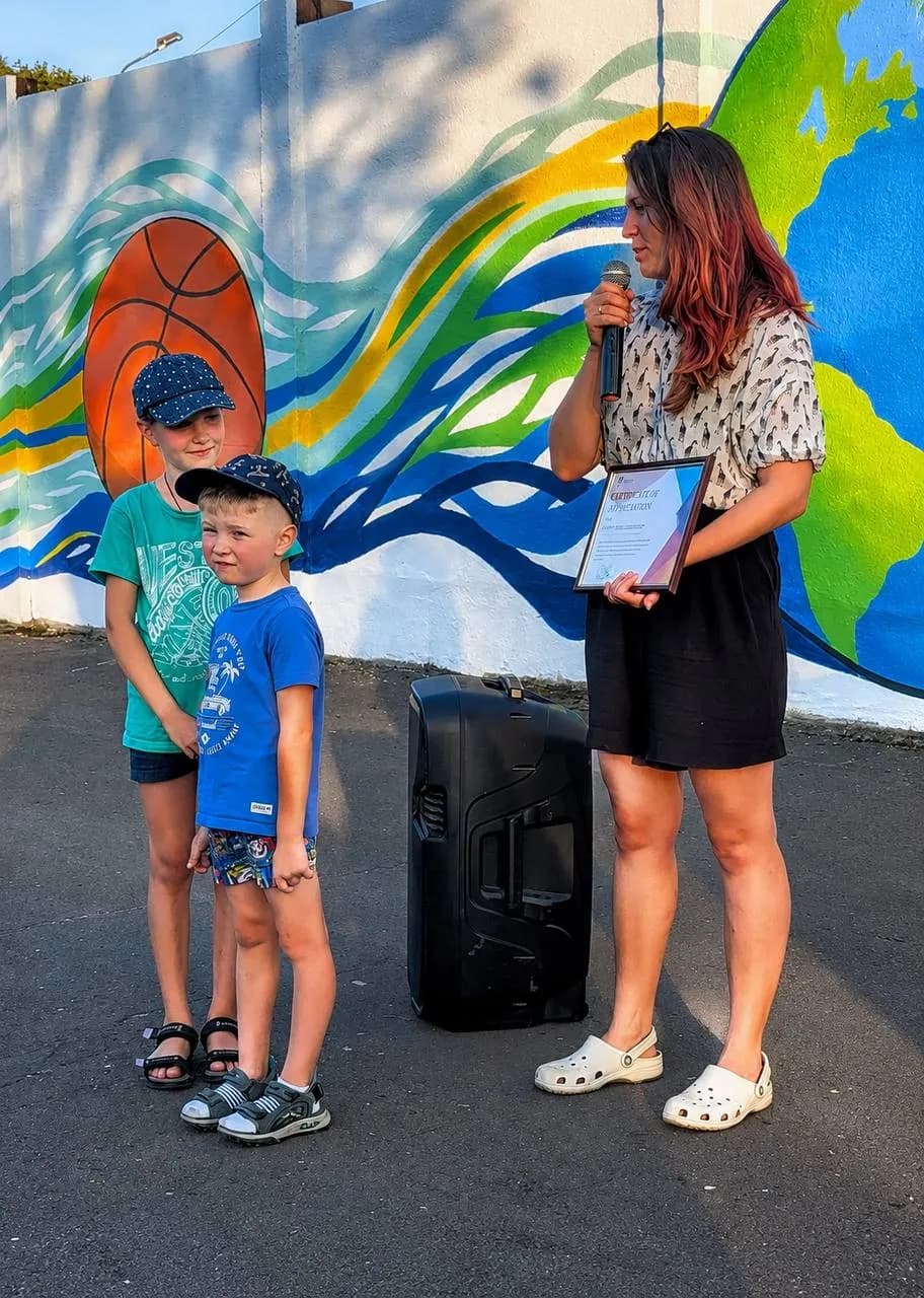 Художниця Ірина Водолажченко дякує діткам-волонтерам, які допомагали їй працювати над муралом