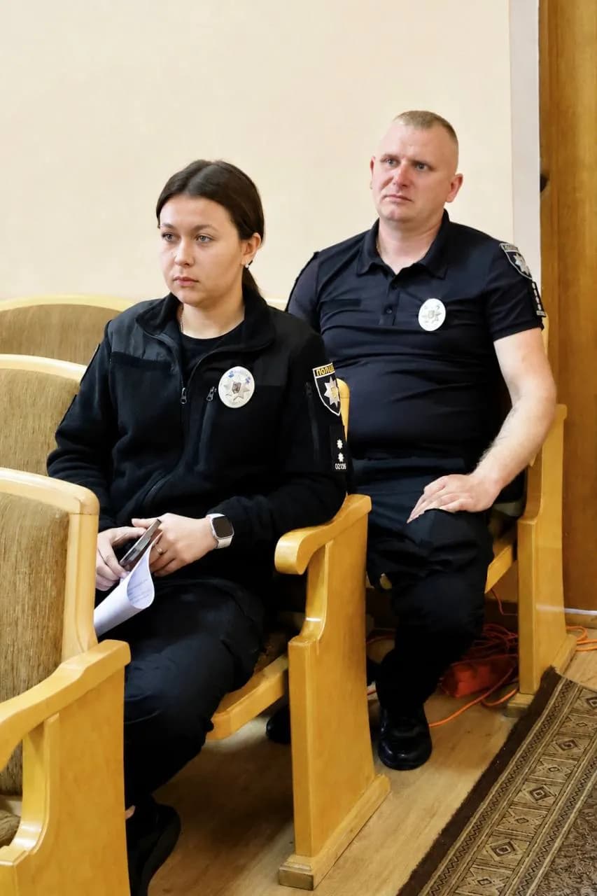 Прліцейський та поліцейська сидять у залі
