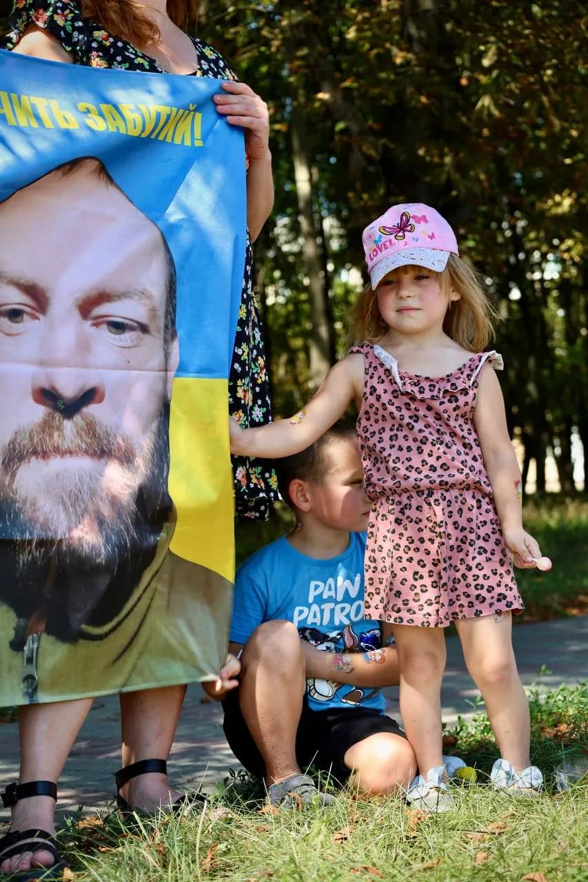 Діти тримають прапор з портретом зниклого безвісти тата