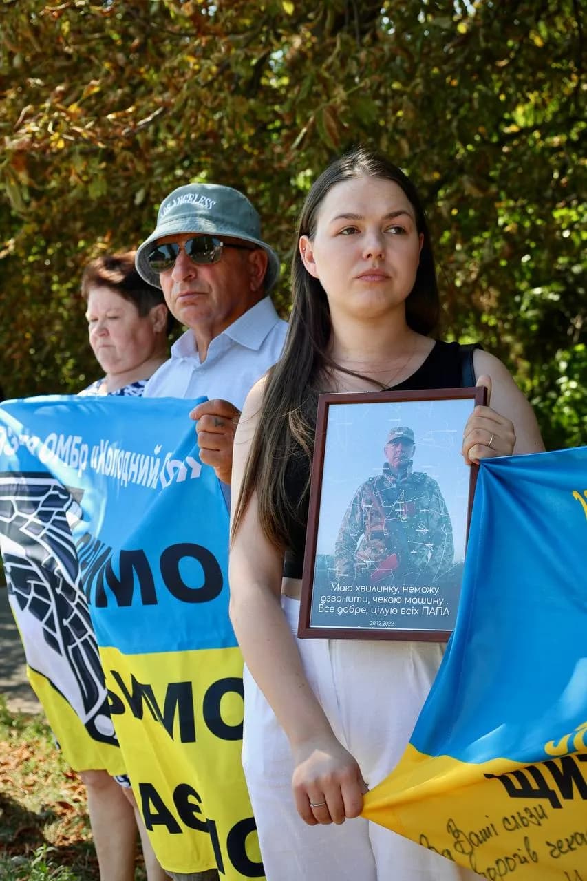 Люди з прапорами та портретами зниклих безвісти родичів