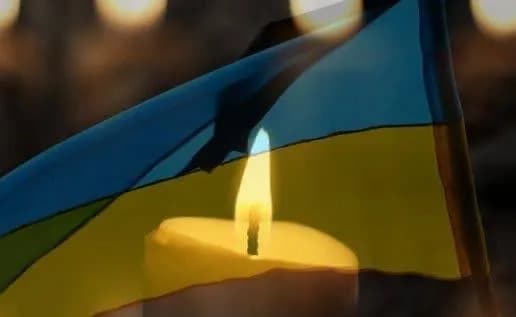 Свічка на фоні українського прапора