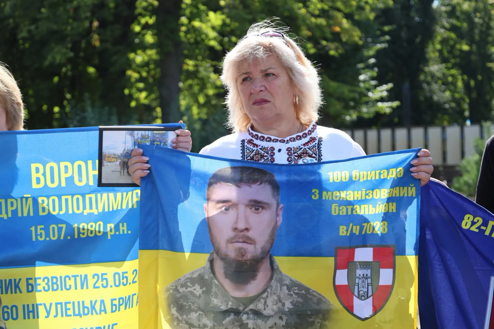 жінка з прапором, на якому портрет воіна