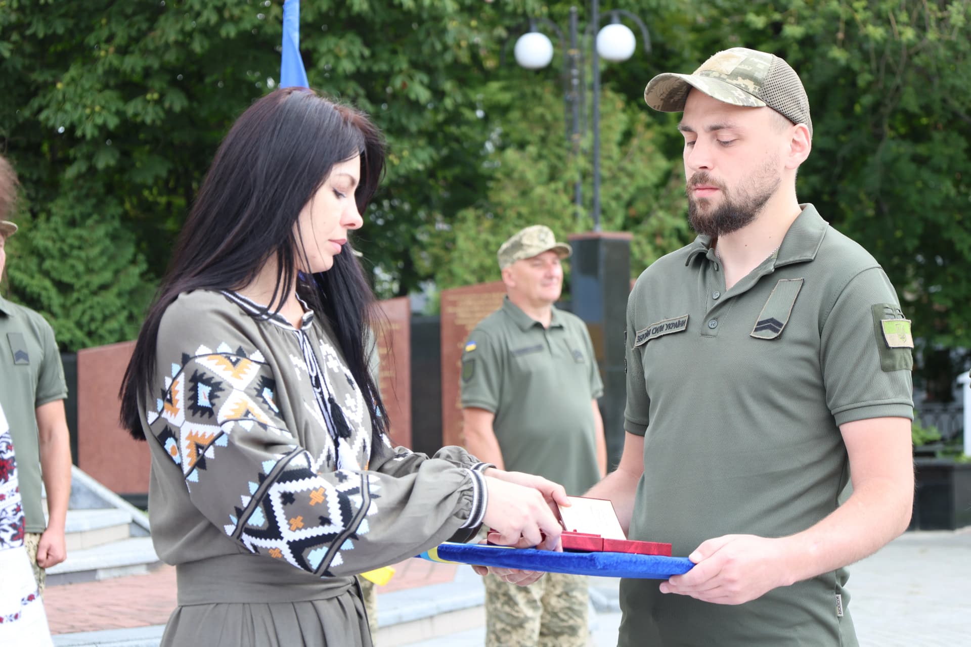 військовий передає нагороду ведучій