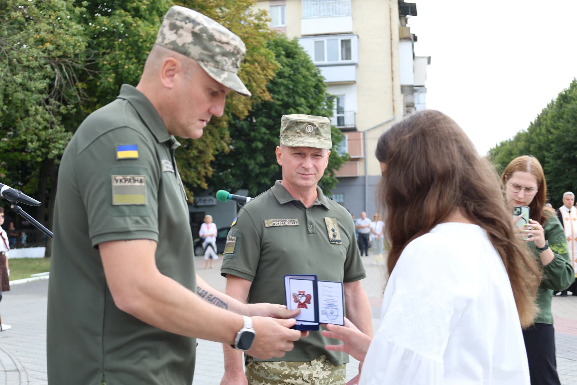 військовий вручає нагороду доньці Героя