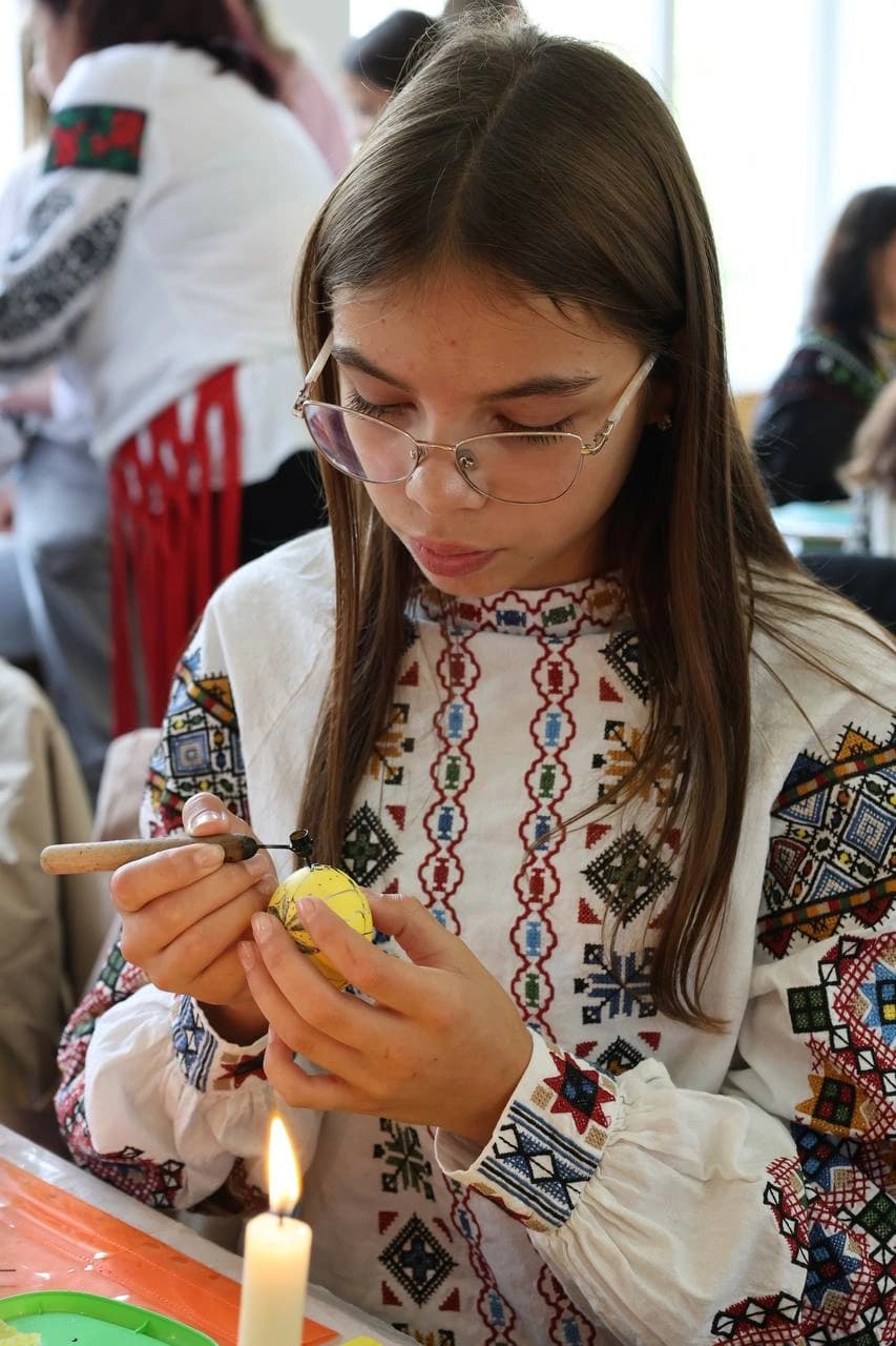 Дівчинка писанкує