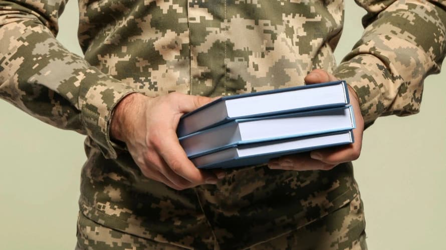 ветеран тримає книги в руках