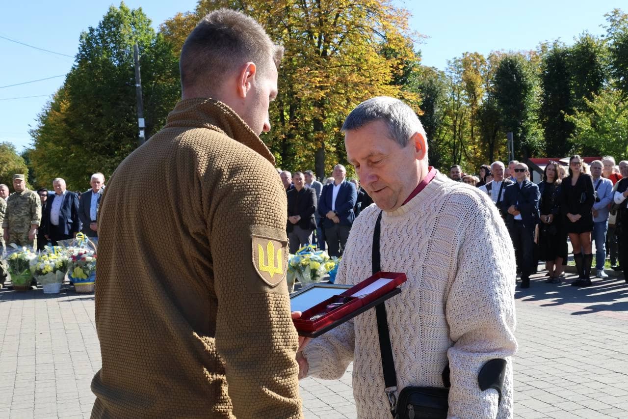 начальник Шептицького РТЦК та СП, підполковник Олександр Нодянош вручає медаль "За поранення" військовому