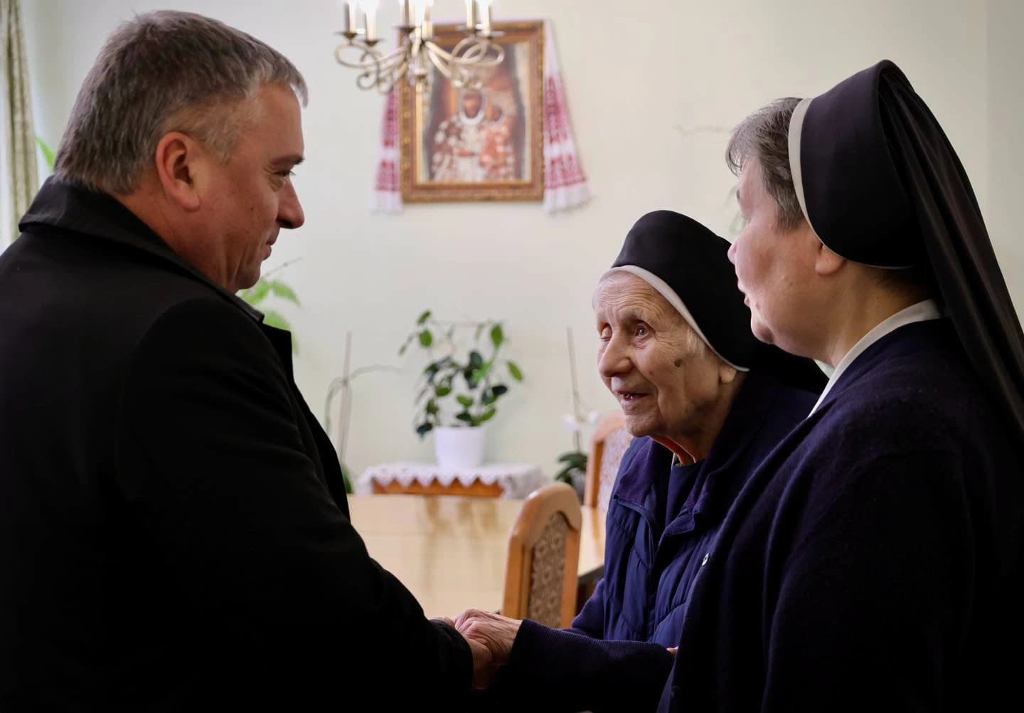 заступник міського голови Володимир Коваль вітає сестру Дарію Градюк зі 101-річчям