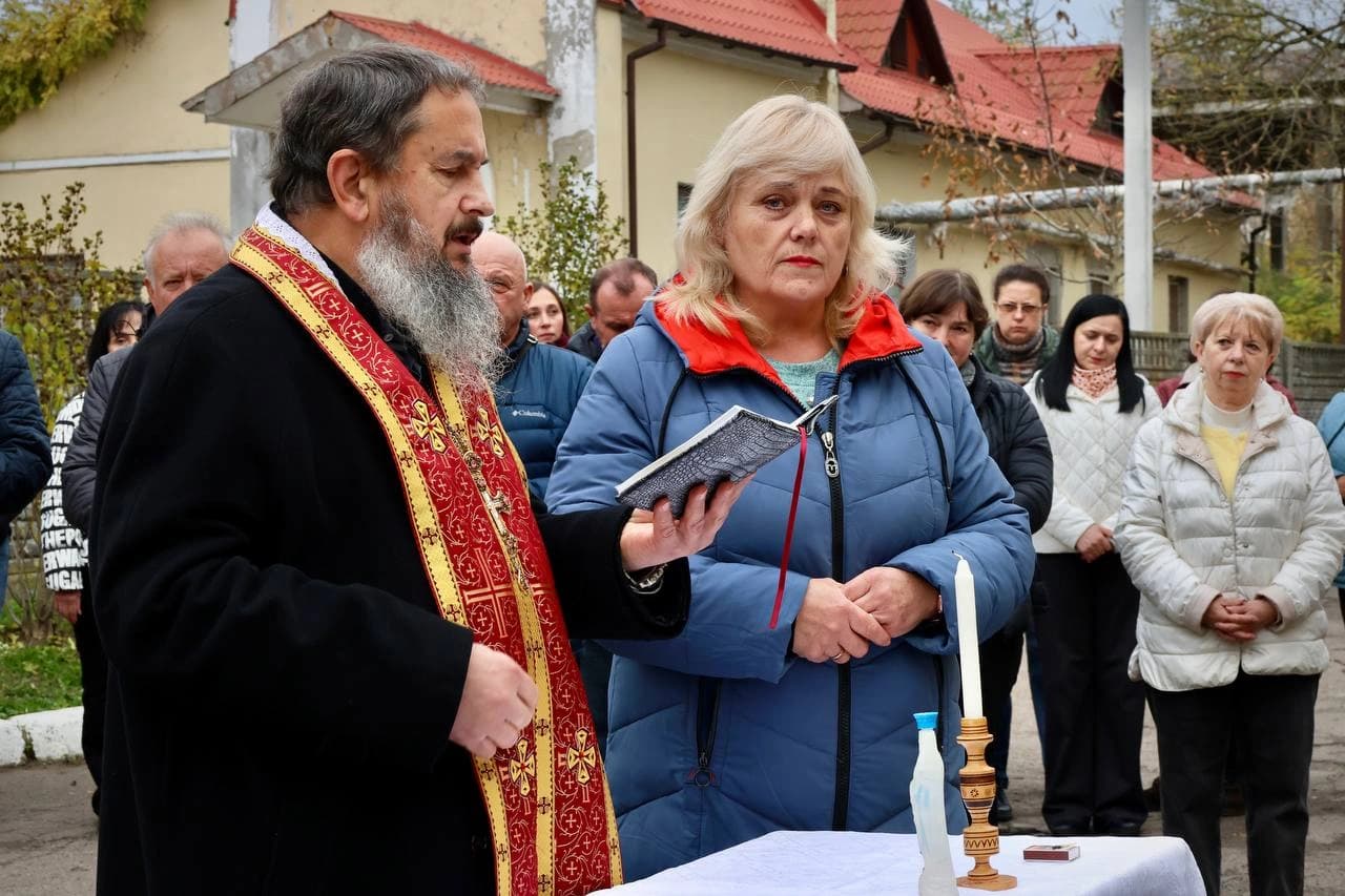 Отець Мирослав Банах читає молитву під час відкриття меморіальної дошки